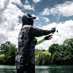 Person fishing on a lake with trees and clouds in the background