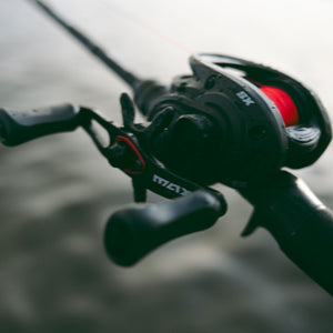 Abu Garcia MAX SX Baitcasting Reel close up shot, with red line and blurred background
